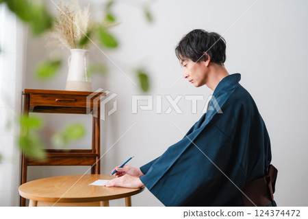 Quiet moment - Man in traditional Japanese clothing writing a letter Quiet moment - Man in traditional Japanese clothing writing a letter 124374472