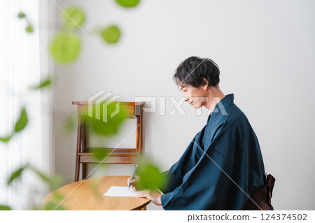 Quiet moment - Man in traditional Japanese clothing writing a letter Quiet moment - Man in traditional Japanese clothing writing a letter 124374502