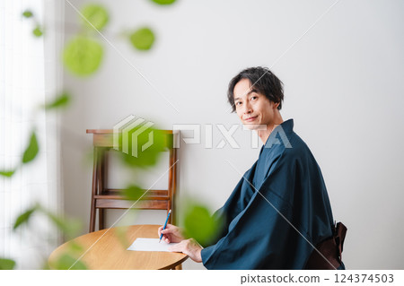 Quiet moment - Man in traditional Japanese clothing writing a letter Quiet moment - Man in traditional Japanese clothing writing a letter 124374503