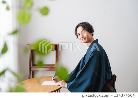 Quiet moment - Man in traditional Japanese clothing writing a letter Quiet moment - Man in traditional Japanese clothing writing a letter 124374504
