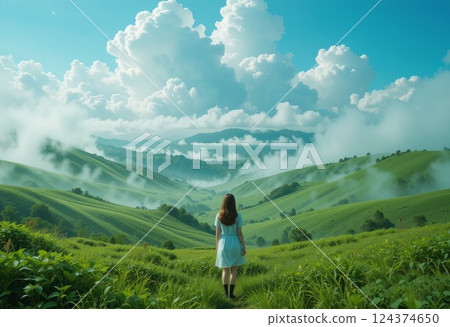 Girl in green landscape. Mist and clouds under blue skies. Girl in green landscape. Mist and clouds under blue skies. 124374650