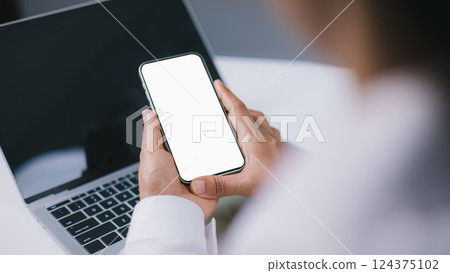 Design creative work space, Business Woman using smartphone, Social media advertisement, Cell phone white screen mockup, Human hand holding mobile phone with blank screen while working at office. 124375102