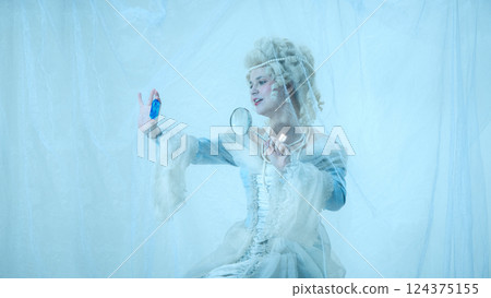 Young elegant woman in vintage dress exploring crystal through magnifying glass, fantasy meets science Young elegant woman in vintage dress exploring crystal through magnifying glass, fantasy meets science 124375155