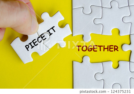 Piece it together text on missing jigsaw puzzle representing teamwork and unity. Teamwork concept 124375231