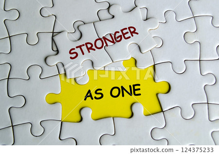 Stronger As One text on missing jigsaw puzzle. One Team and Unity concept 124375233