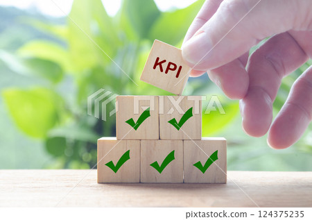 Hand holding wooden cube with text KPI. Key Performance Indicator concept. 124375235