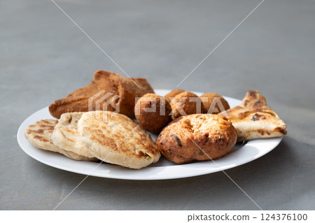 Authentic Sri Lankan different street food, short eats. Vegetable roti, Chinese Rolls , coconut roti, cutlets, mutton rolls on gray background. Snacks made with tuna, potatoes, onion and deep fried 124376100