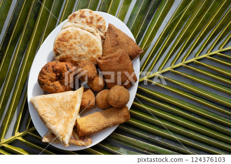 Authentic Sri Lankan different street food, short eats. Vegetable roti, coconut roti, cutlets, mutton rolls on white plate. View from above. Copy space. Authentic Sri Lankan different street food, short eats. Vegetable roti, coconut roti, cutlets, mutton rolls on white plate. View from above. Copy space. 124376103