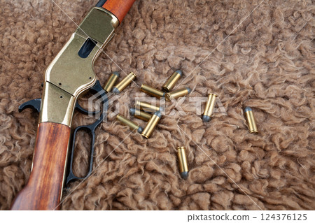 Lever action rifle and ammunition on fur 124376125