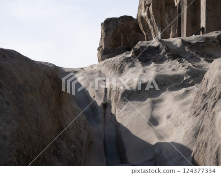 Sunlight illuminates the rocky terrain leading to a historic site 124377334