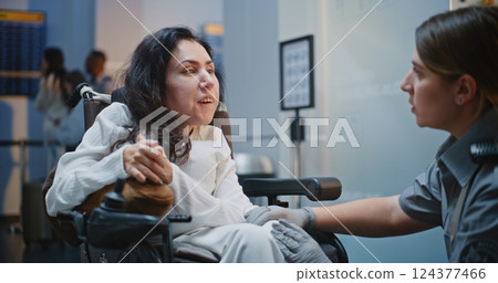Security Checkpoint: Female TSA Officer Checking Woman with Physical Disability in Airport Terminal 124377466