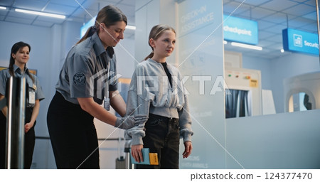 Female Officer Inspects Teenage Girl For Boarding Plane Flight. Young Tourist Going on Trip Female Officer Inspects Teenage Girl For Boarding Plane Flight. Young Tourist Going on Trip 124377470