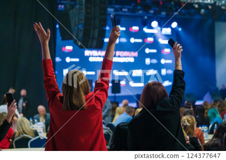 People enjoying a vibrant stage event with excitement and energy People enjoying a vibrant stage event with excitement and energy 124377647