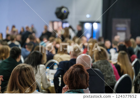 Audience at business event in conference hall focusing on speaker on stage Audience at business event in conference hall focusing on speaker on stage 124377652