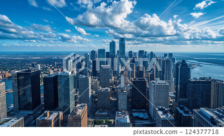 Metropolis skyline reaching for a cloudy blue sky 124377718