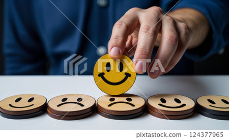 Businessman choosing positive feedback, placing yellow smiley face on top of others 124377965