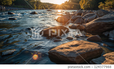 River flowing at sunset between rocks and trees 124377988