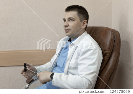 Male doctor holding reflex nerve in hand, focus on instrument Male doctor holding reflex nerve in hand, focus on instrument 124378069