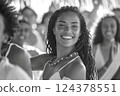 Happy woman smiling in a blackandwhite photo with a crowd at a fun event 124378551