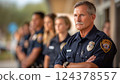 A male police officer looks through the lens at the background of his fellow officers 124378557