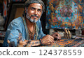 Man with facial hair admires art painting at table, artist with beard 124378559