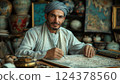 A human artist in a turban sits at a table, sharing their art on paper 124378560