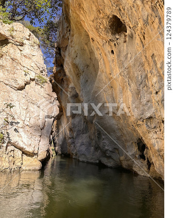 Majestic rock formations surrounding tranquil water in a serene natural setting showcasing nature's beauty concept 124379789
