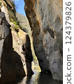 Majestic rock formations towering over tranquil waters in a stunning canyon landscape nature exploration concept 124379826