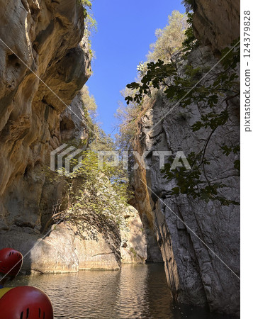 Majestic rock formations towering over serene waterway under clear blue sky in stunning natural landscape concept 124379828