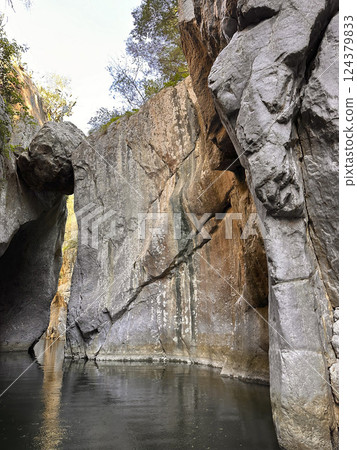Majestic rock formations towering over tranquil water in a serene canyon landscape natural beauty concept Majestic rock formations towering over tranquil water in a serene canyon landscape natural beauty concept 124379833