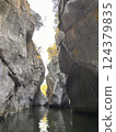 Majestic rock formations towering over tranquil waterway in scenic canyon landscape nature exploration concept 124379835