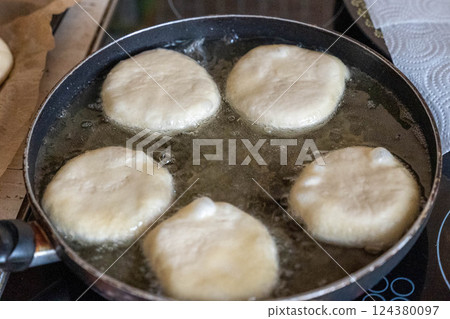 Chef frying dough in hot oil in frying pan Chef frying dough in hot oil in frying pan 124380097