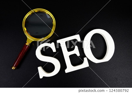 Seo words (Search Engine Optimization) letters with magnifying glass on black background 124380792