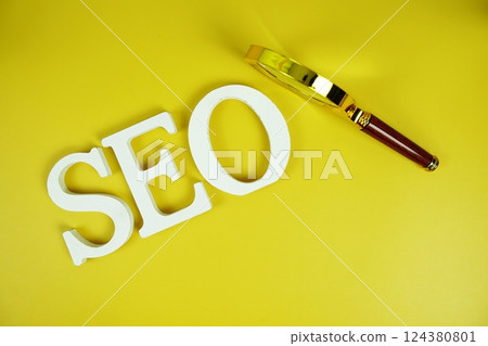 SEO alphabet letter with magnifying glass on yellow background 124380801