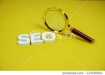 SEO alphabet letter with magnifying glass on yellow background SEO alphabet letter with magnifying glass on yellow background 124380803