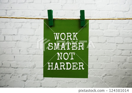 Work smater not harder text on paper card hanging with rope on white brick background 124381014