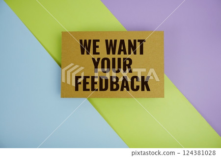 We Want Your Feedback text written on paper top view on purple green and blue geometric background We Want Your Feedback text written on paper top view on purple green and blue geometric background 124381028