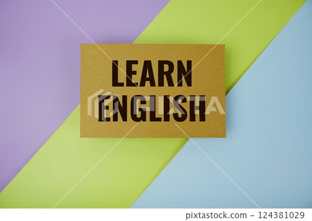 Learn English text written on paper top view on purple green and blue geometric background Learn English text written on paper top view on purple green and blue geometric background 124381029