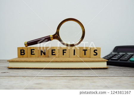 Magnifying glass and calculator with wooden blocks alphabet letters BENEFITS text message on wooden background 124381167