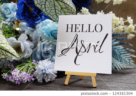 Hello April text write on paper card with wooden easel and flowers decoration on wooden background Hello April text write on paper card with wooden easel and flowers decoration on wooden background 124381304