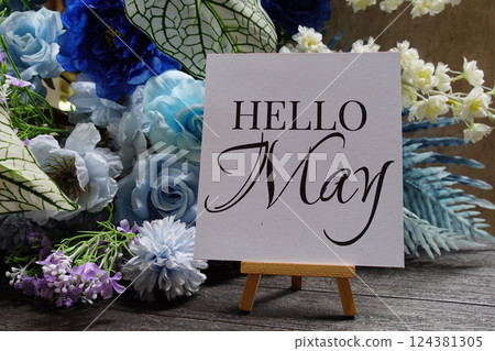 Hello May text write on paper card with wooden easel and flowers decoration on wooden background Hello May text write on paper card with wooden easel and flowers decoration on wooden background 124381305