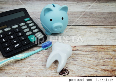 Toothbrush dental hygiene concept with calculator and piggy saving on wooden background, Dental money and dentist treatment costs 124381446