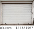Closed white metal garage door with dirt stains 124381567