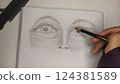 drawing face with pencil in sketchbook 124381589