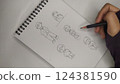 woman hand with pen drawing sketch on a white paper 124381590