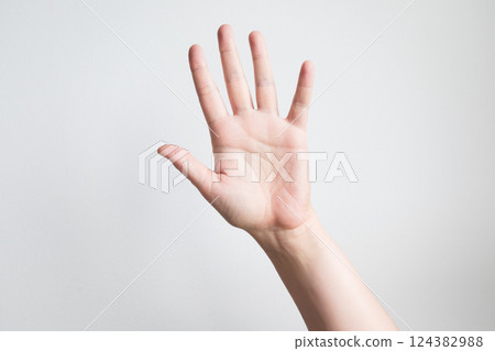 Caucasian adult hand raised against white background with open palm gesture Caucasian adult hand raised against white background with open palm gesture 124382988