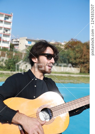 Young Believer Plays Classical Guitar Outdoors Before Mass 124383207