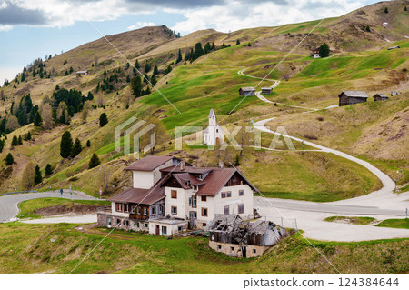 Scenic mountain landscape with country house and winding road leading to a chapel near Valley of Funes at Dolomites, Italy Scenic mountain landscape with country house and winding road leading to a chapel near Valley of Funes at Dolomites, Italy 124384644
