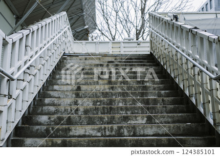 Blackened and dirty stairs on a footbridge 124385101