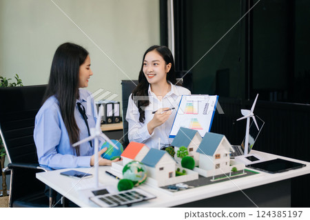 Group of diverse multiethnic businesspeople standing neare table looking at model of building from residential project. Group of diverse multiethnic businesspeople standing neare table looking at model of building from residential project. 124385197